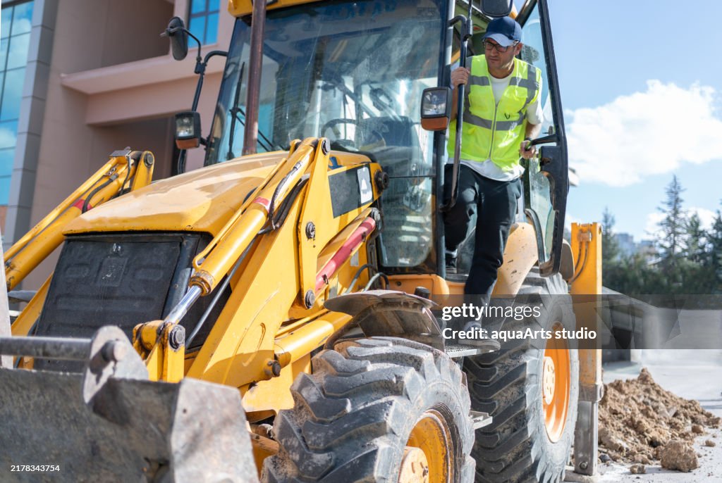 Excavator Operator Working On City Street Road Excavator Operator Working On City Street Road